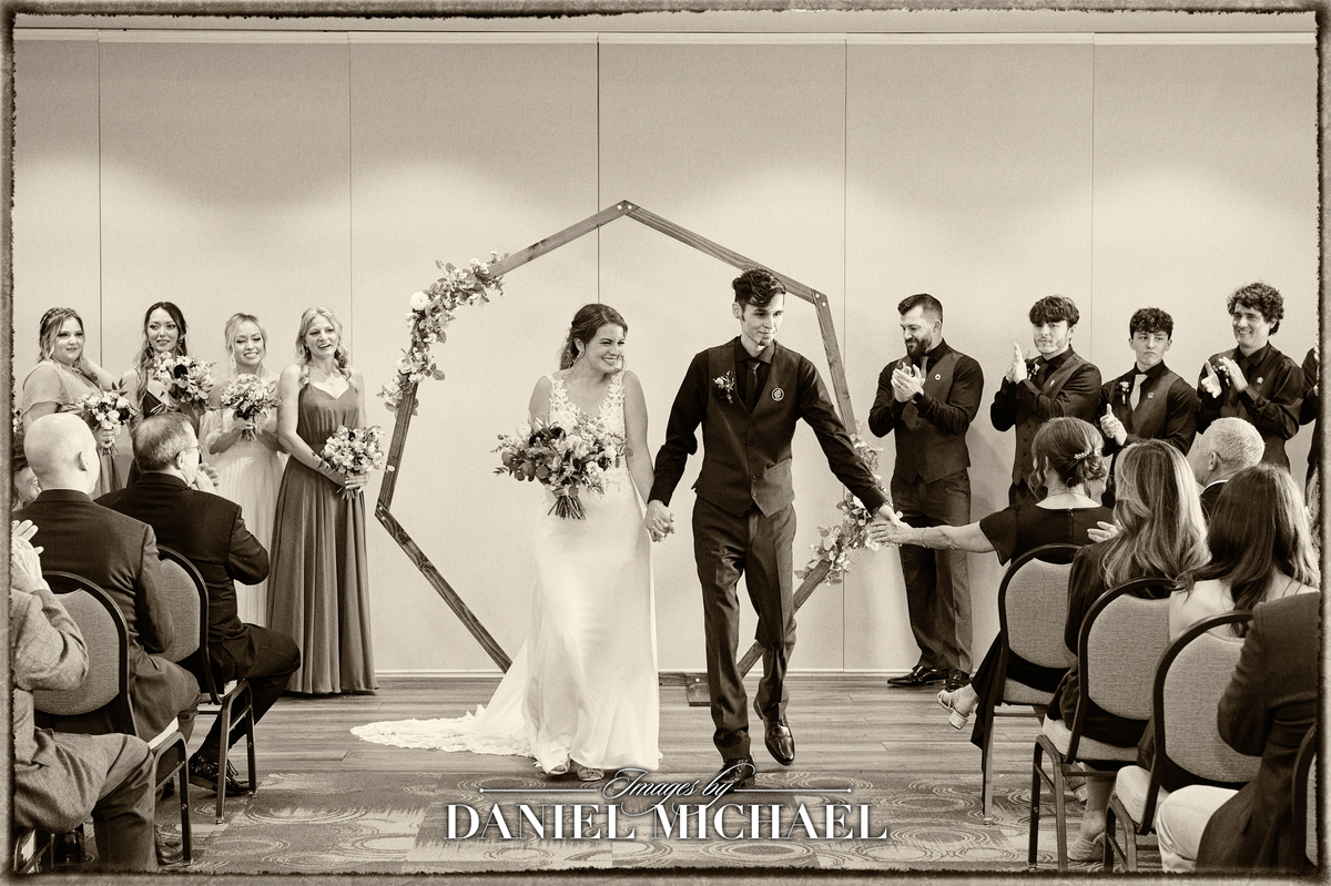 Couple walking down the aisle from wedding party